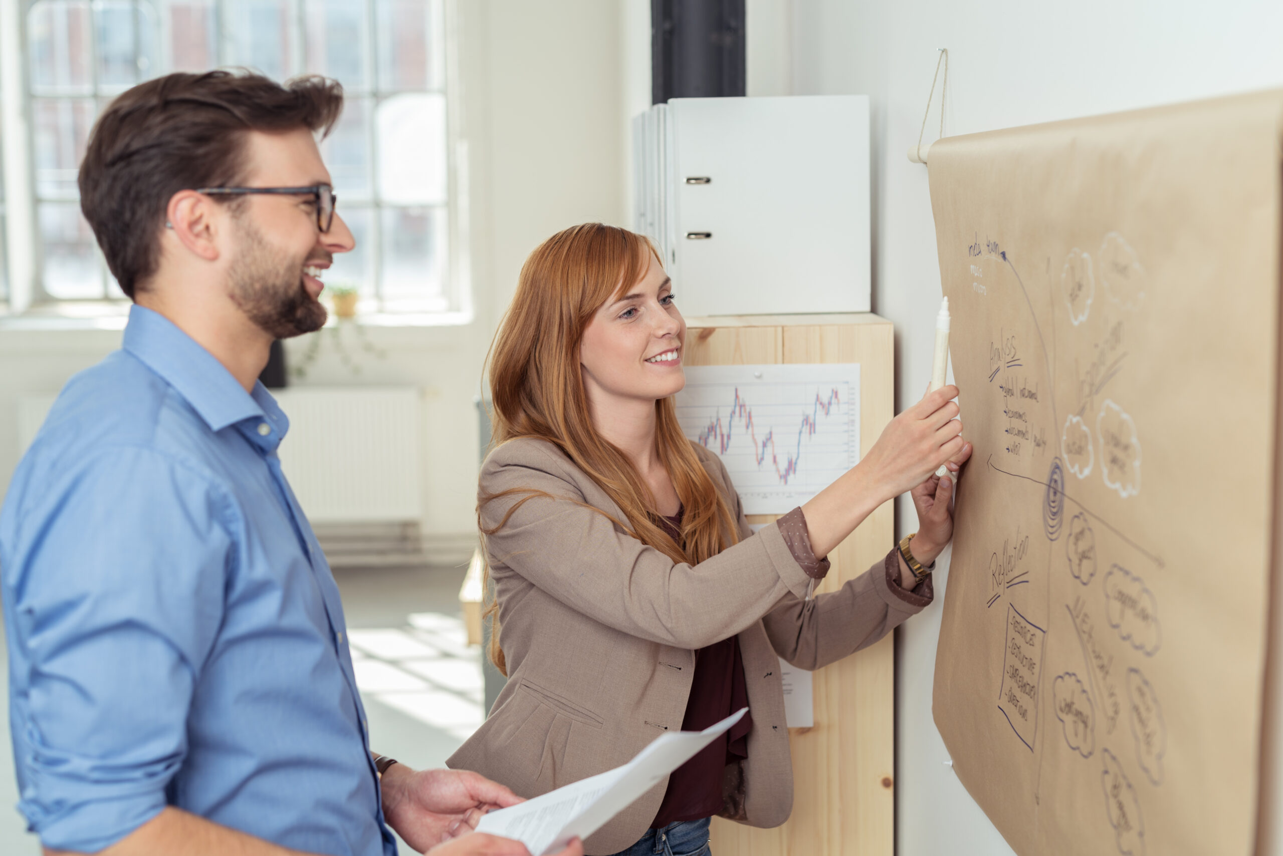 zwei kollegen besprechen ideen für das unternehmen am chart